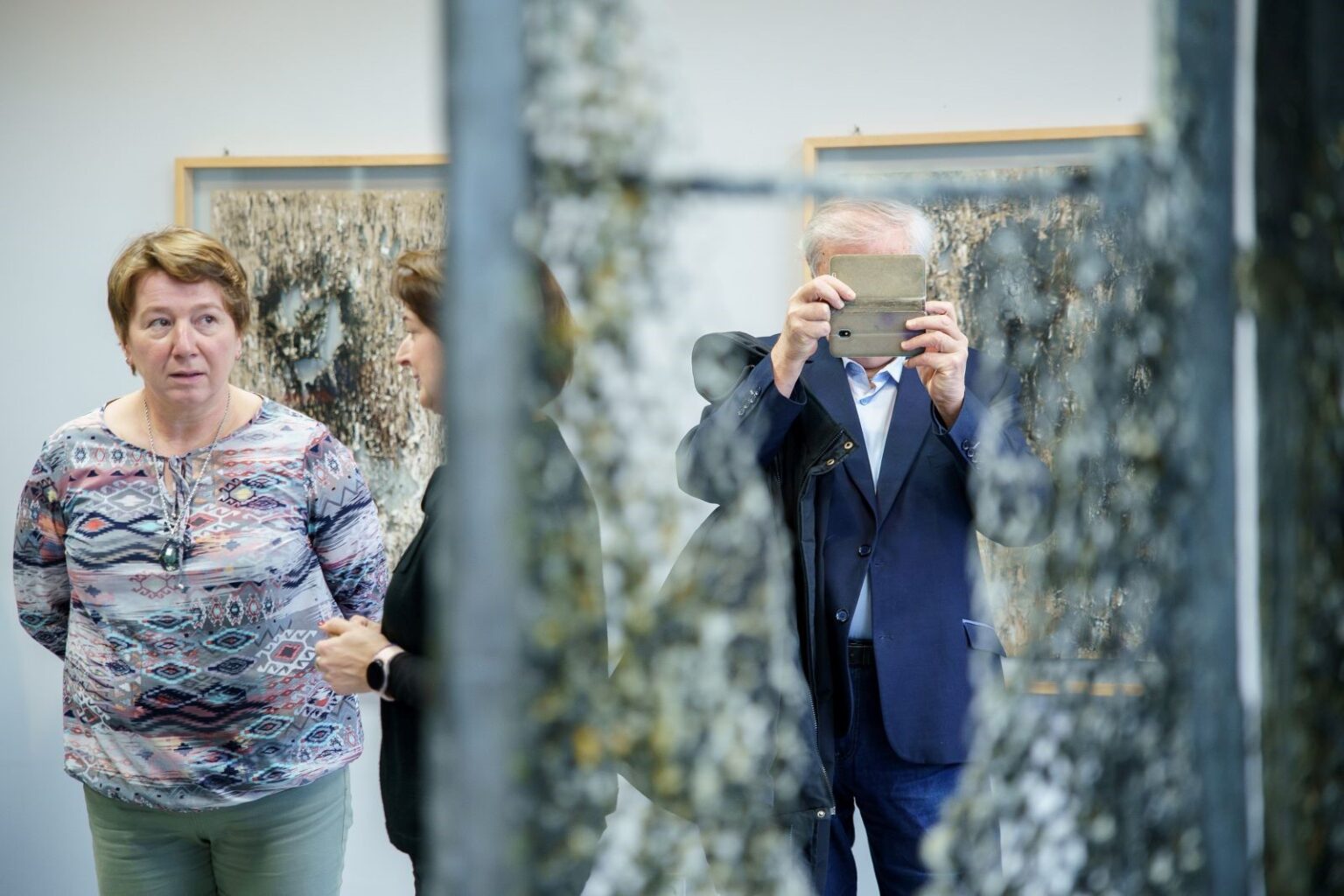 Mężczyzna robi zdjęcie smartfonem obiektów na wystawie