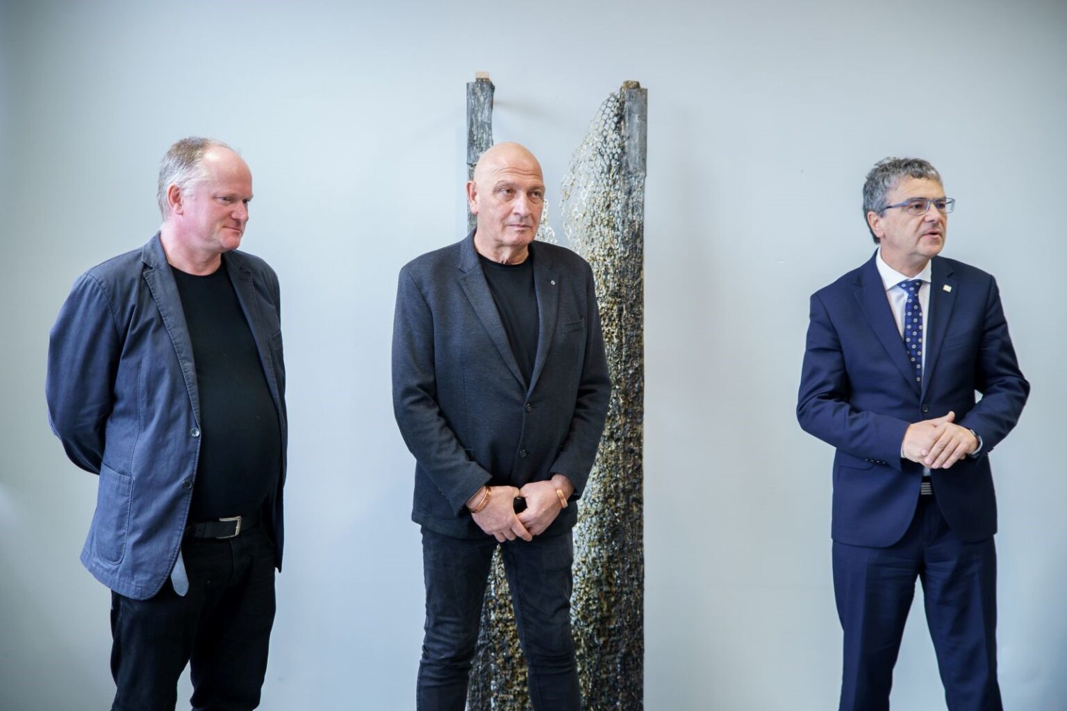 Trzy osoby a tle wystawy