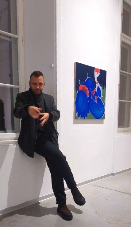 Siedzący mężczyzna. Obraz na ścianie w tle