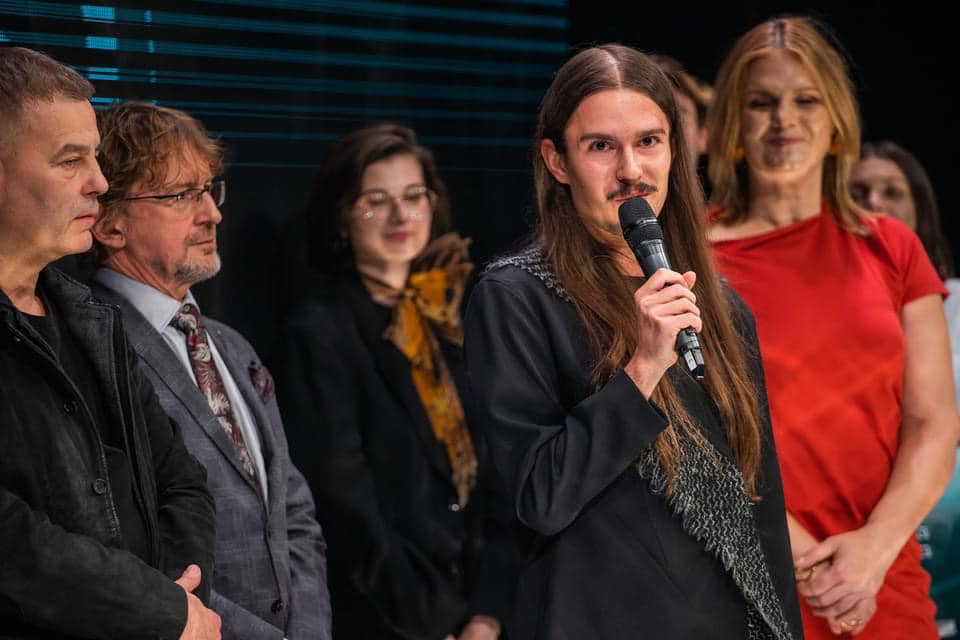 Długowłosy mężczyzna przy mikrofonie