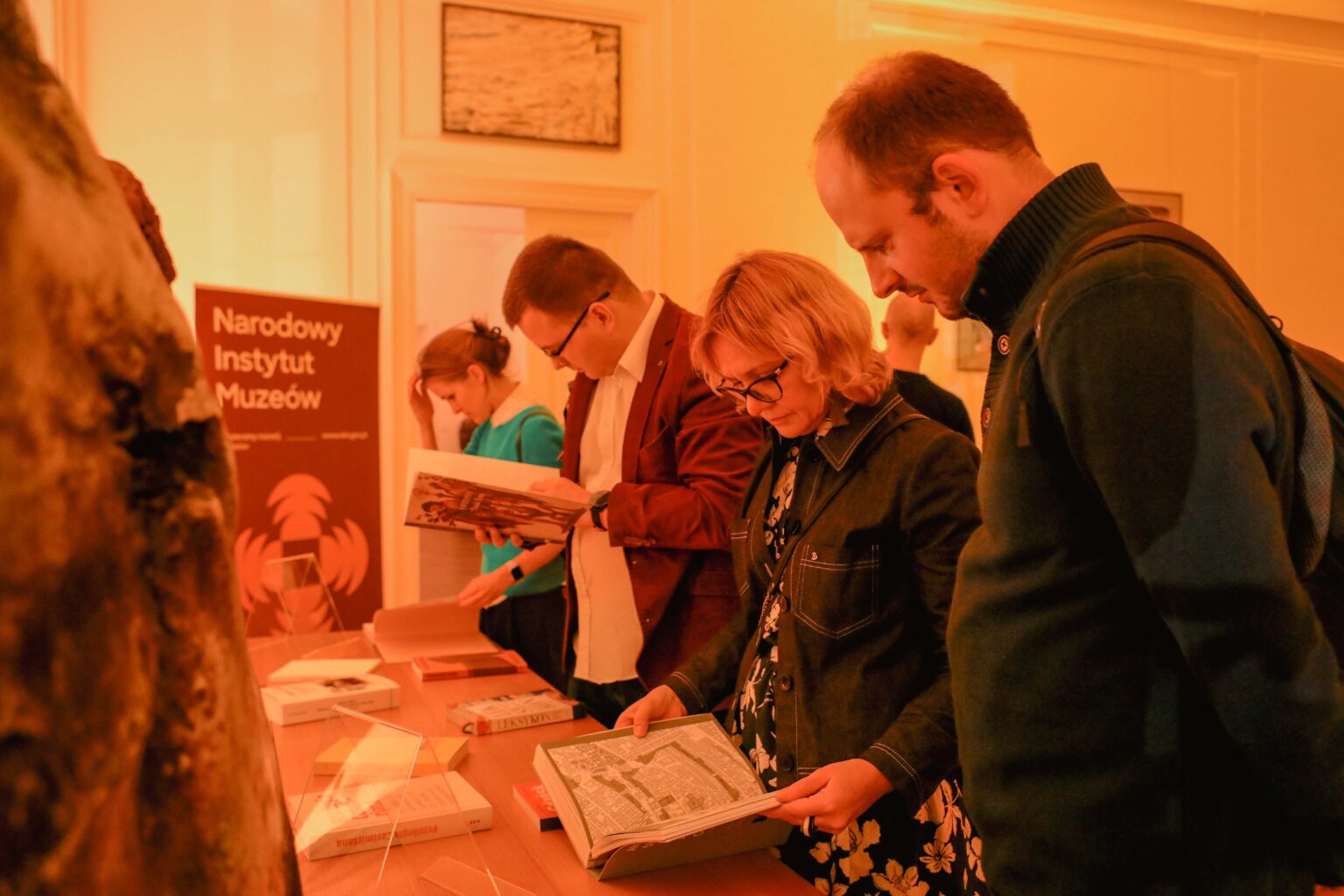 Grupa osób oglądających książki