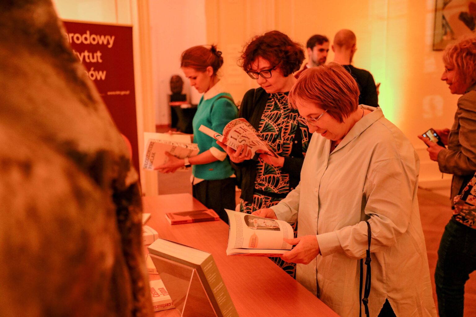 Grupa osób oglądających książki