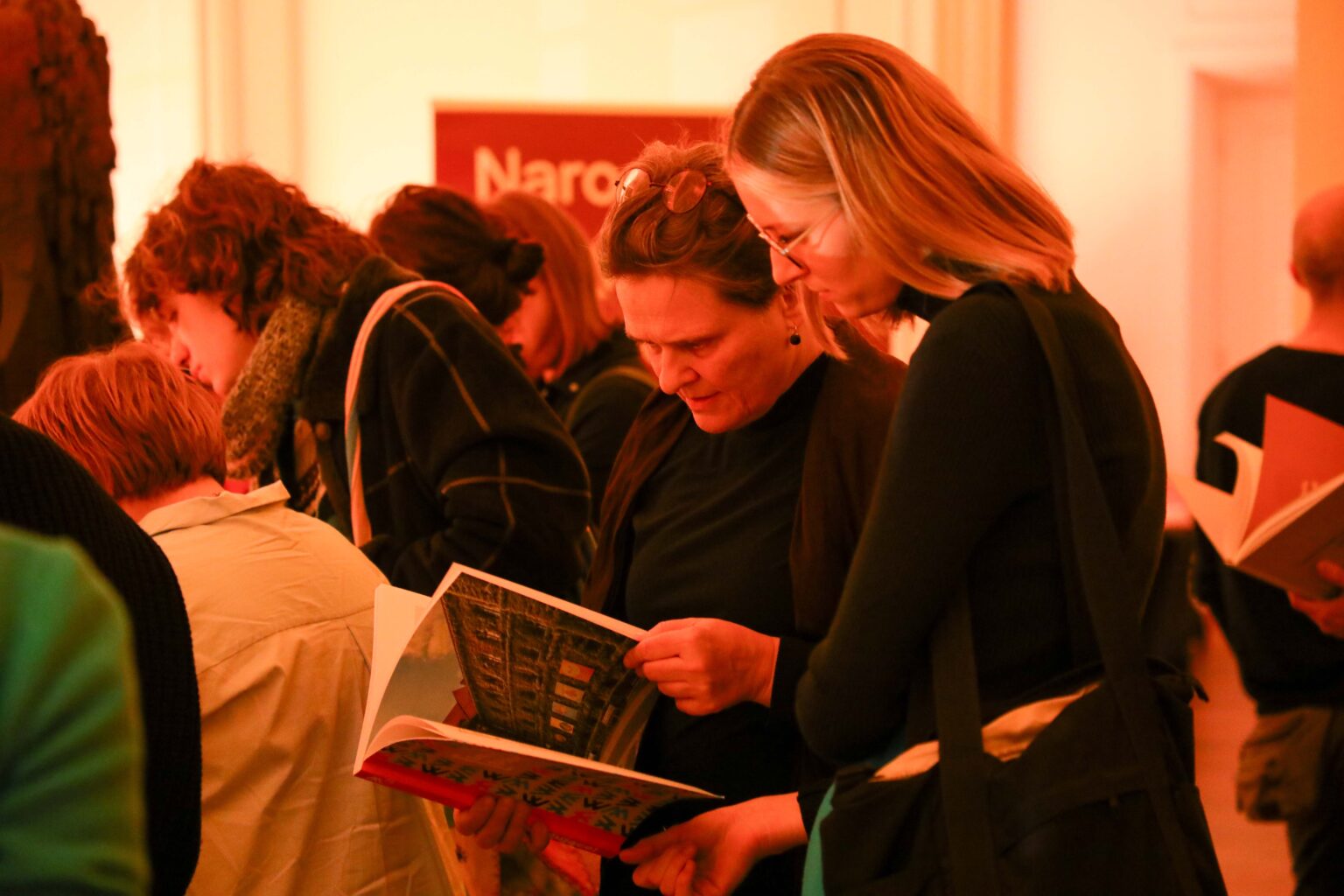 Grupa osób oglądających książki