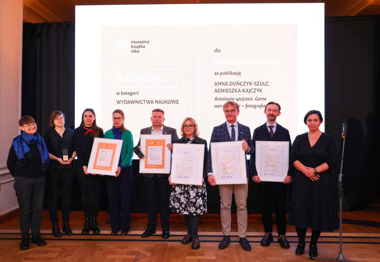 Grupa osób trzymających dyplomy