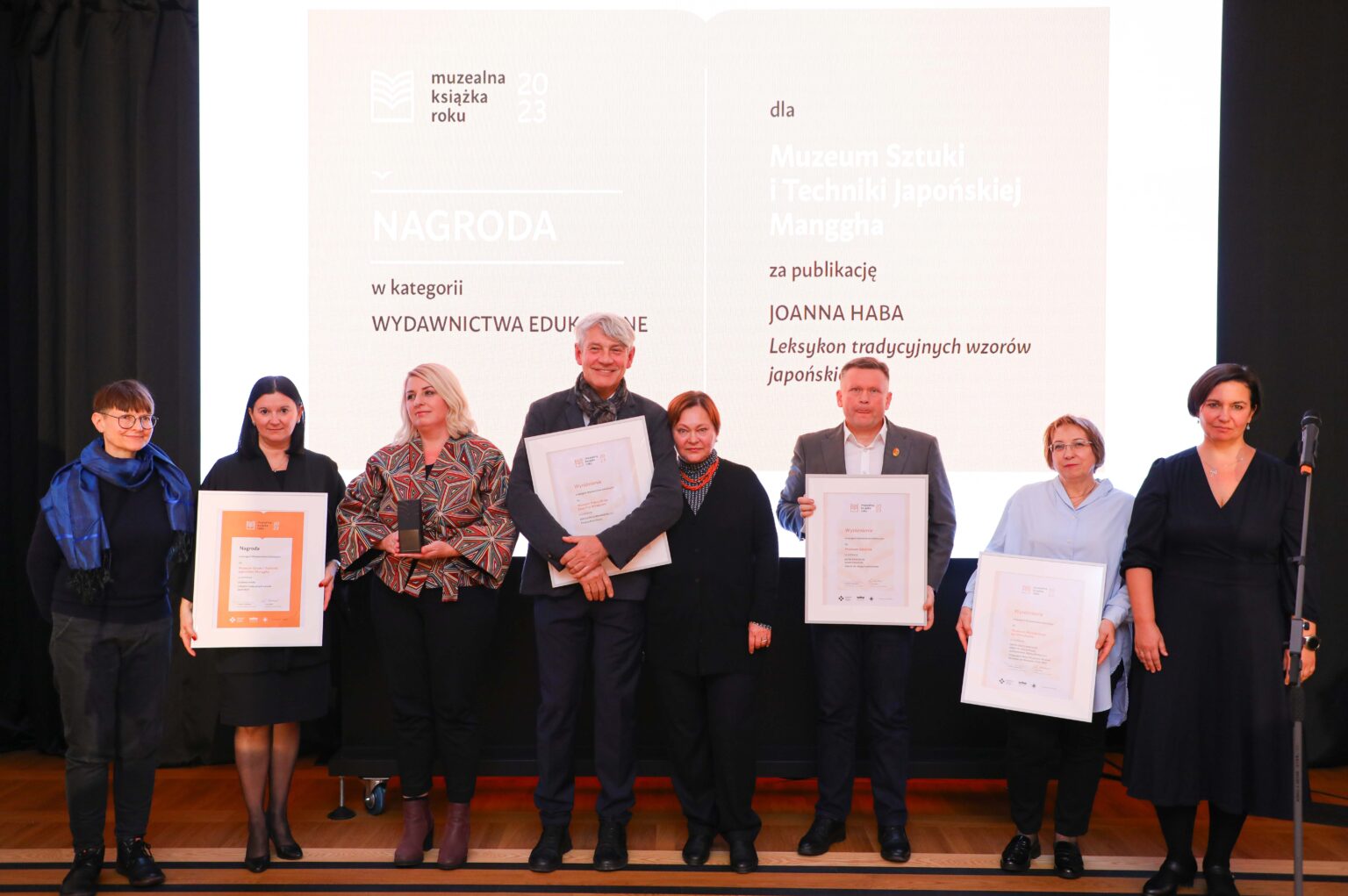 Grupa osób trzymających dyplomy