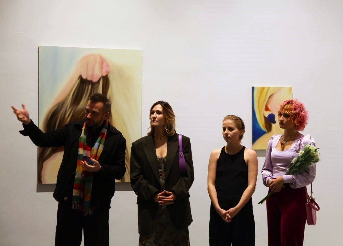 Grupa osób na tle wystawy