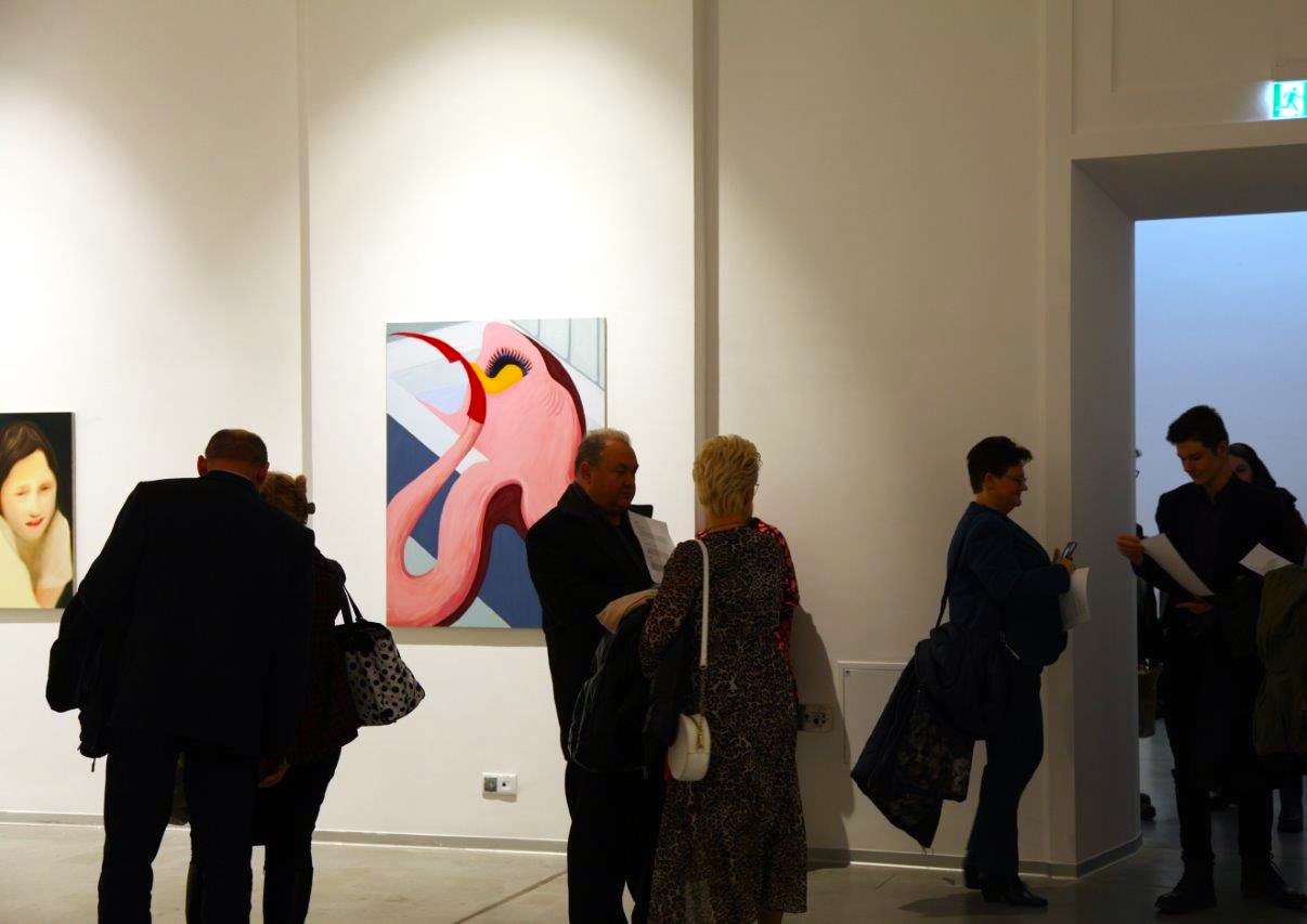 Widok wystawy z osobami oglądającymi