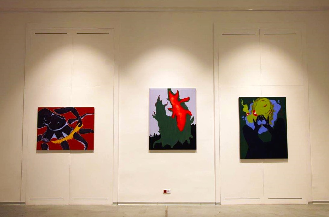 Trzy obrazy na ścianie galerii