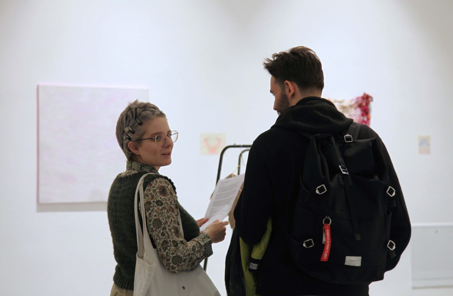 Dwie osoby. widok wystawy w tle