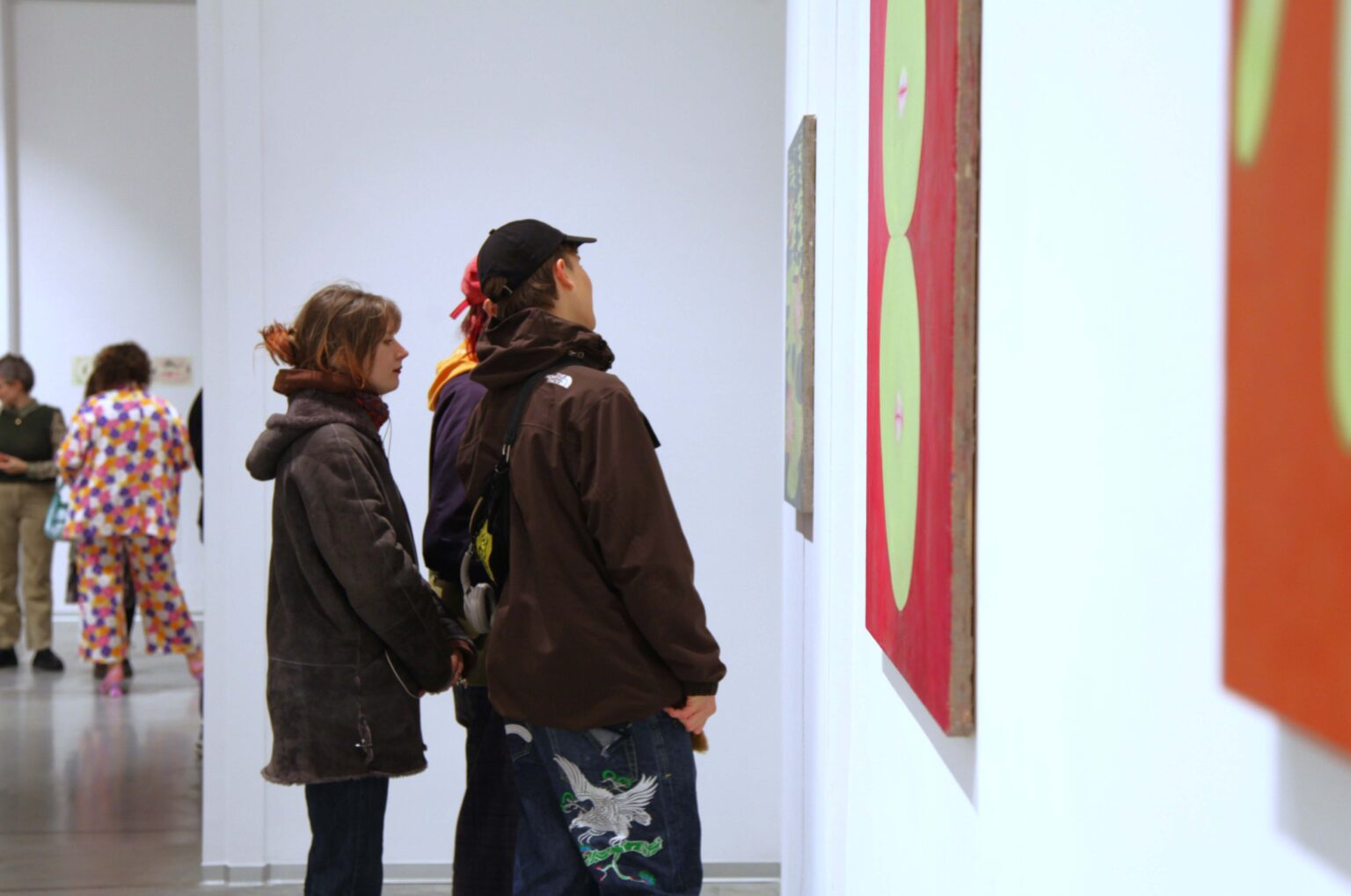 Trzy osoby oglądają obraz