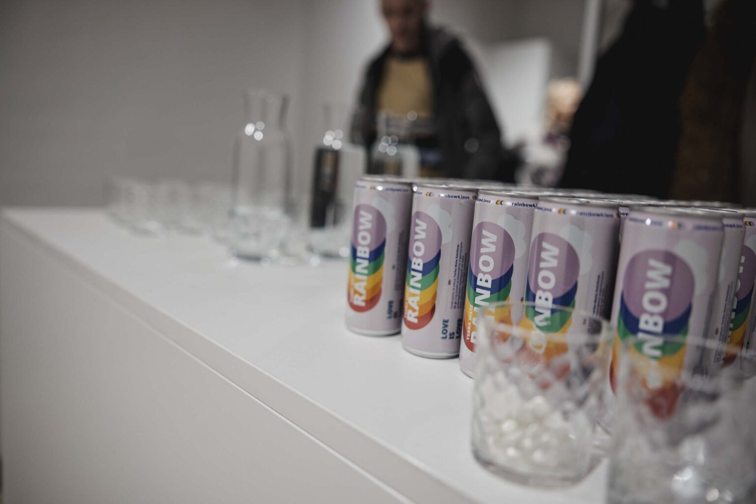 Napoje w tęczowych puszkach ustawione na stole