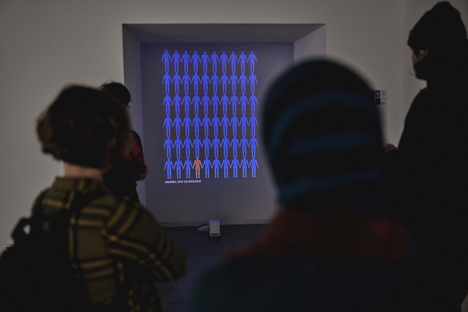 Osoby, w tle wystawa