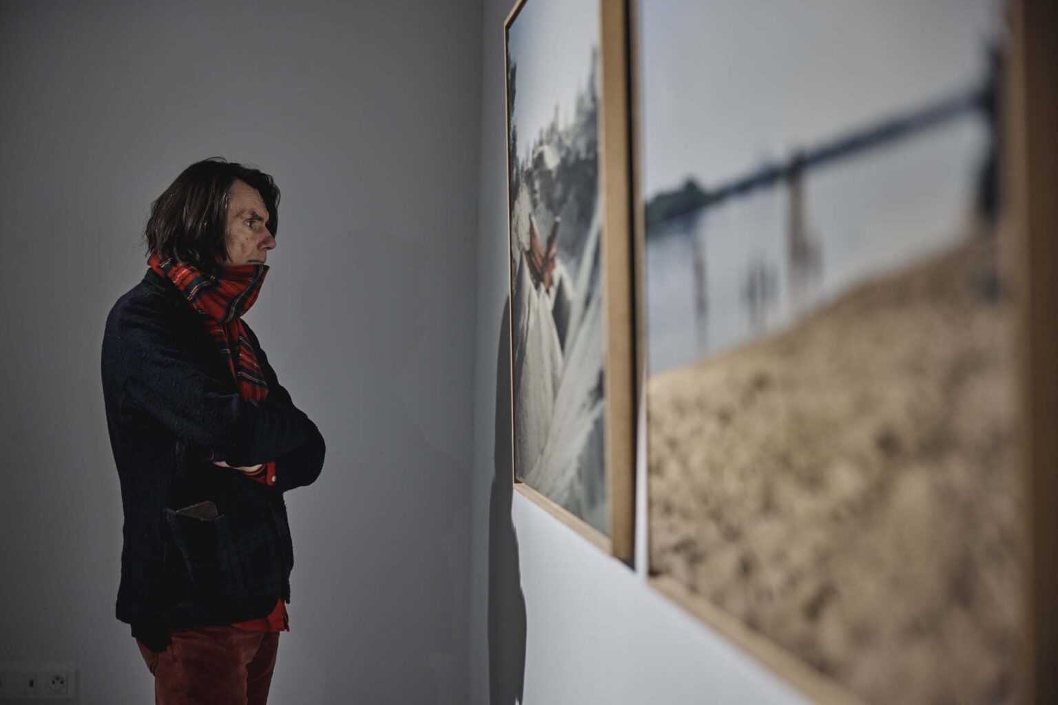 Osoba zwiedzająca ogląda obraz na ścianie galerii