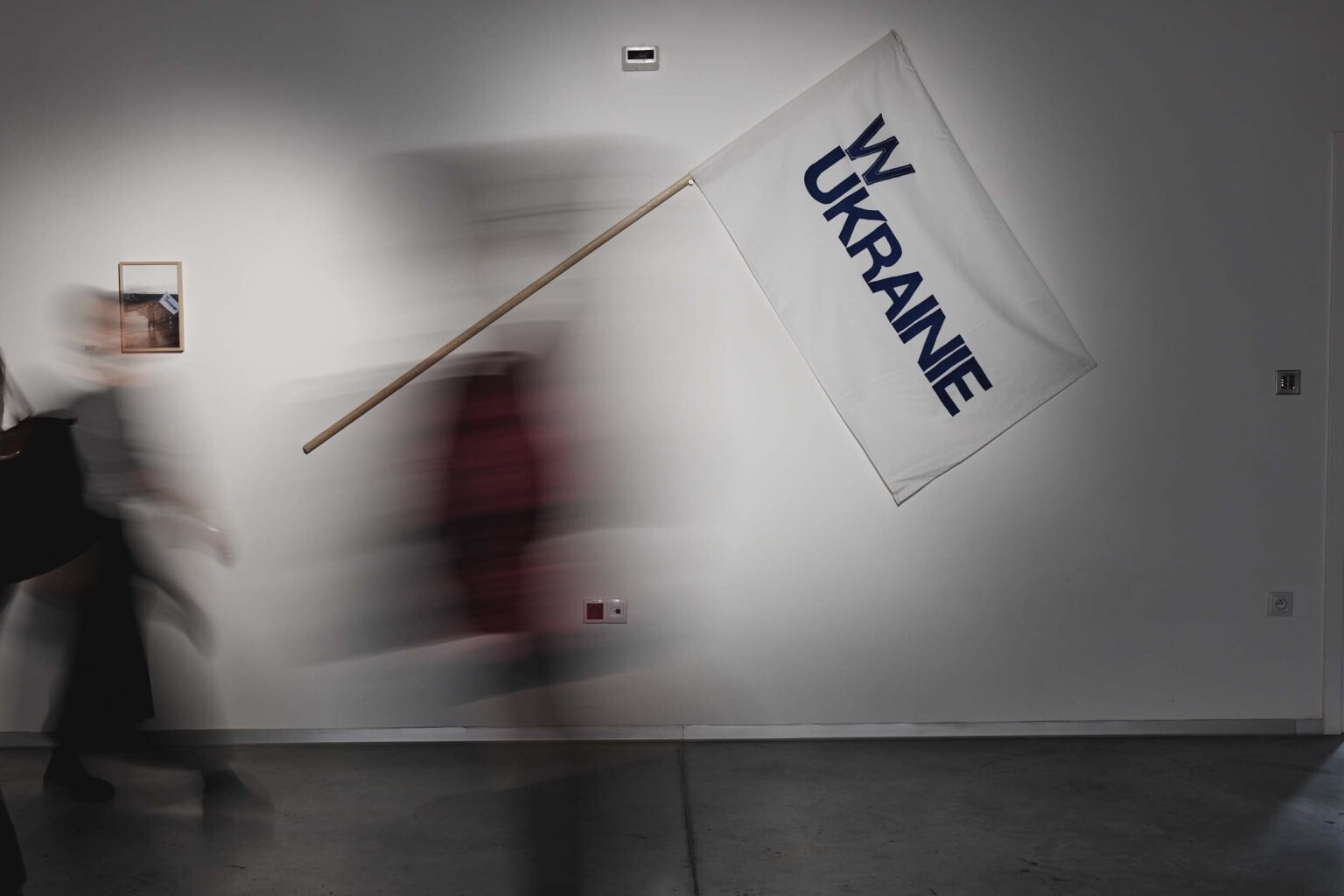 Osoba przechodzaca w transparentem z napisem "W Ukrainie"