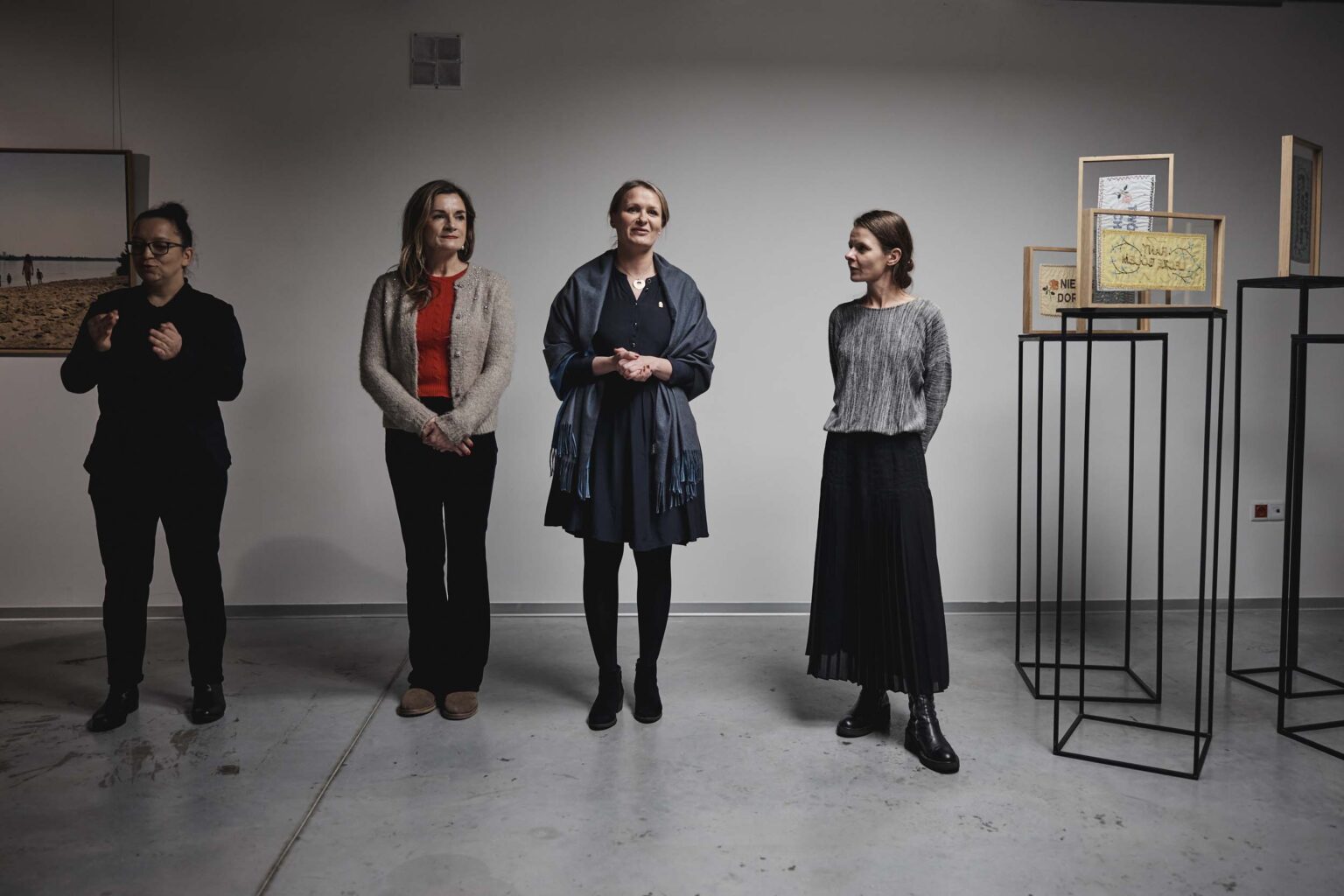 Cztery kobiety stoją w rzędzie. wystawa w tle