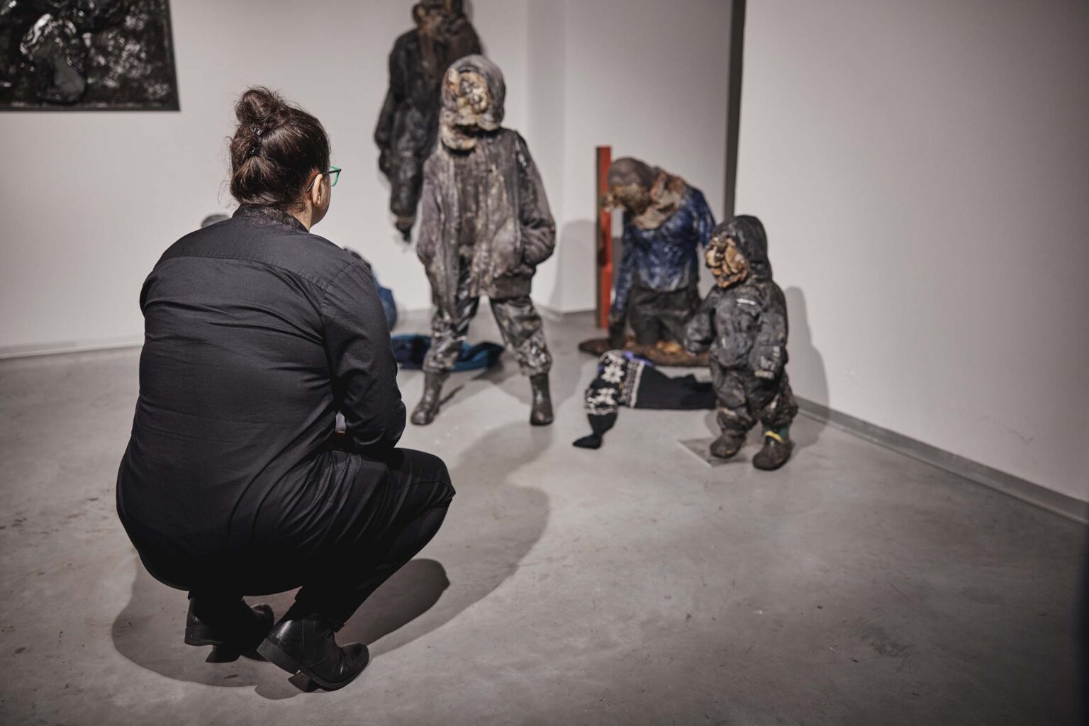 Kobieta kura na przeciwko eksponatów ustawionych na podłodze