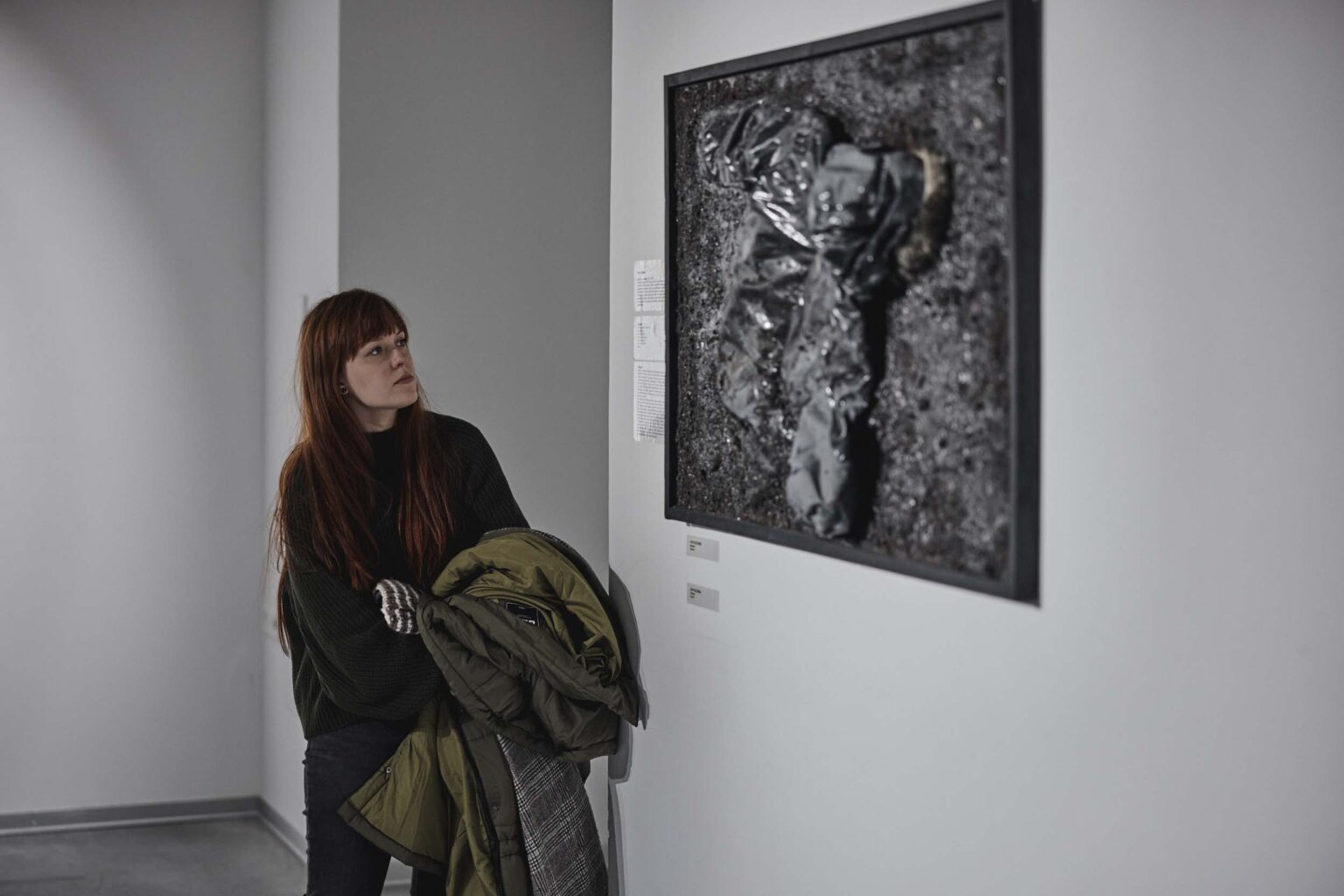 Kobieta oglada eksponat na ścianie galerii