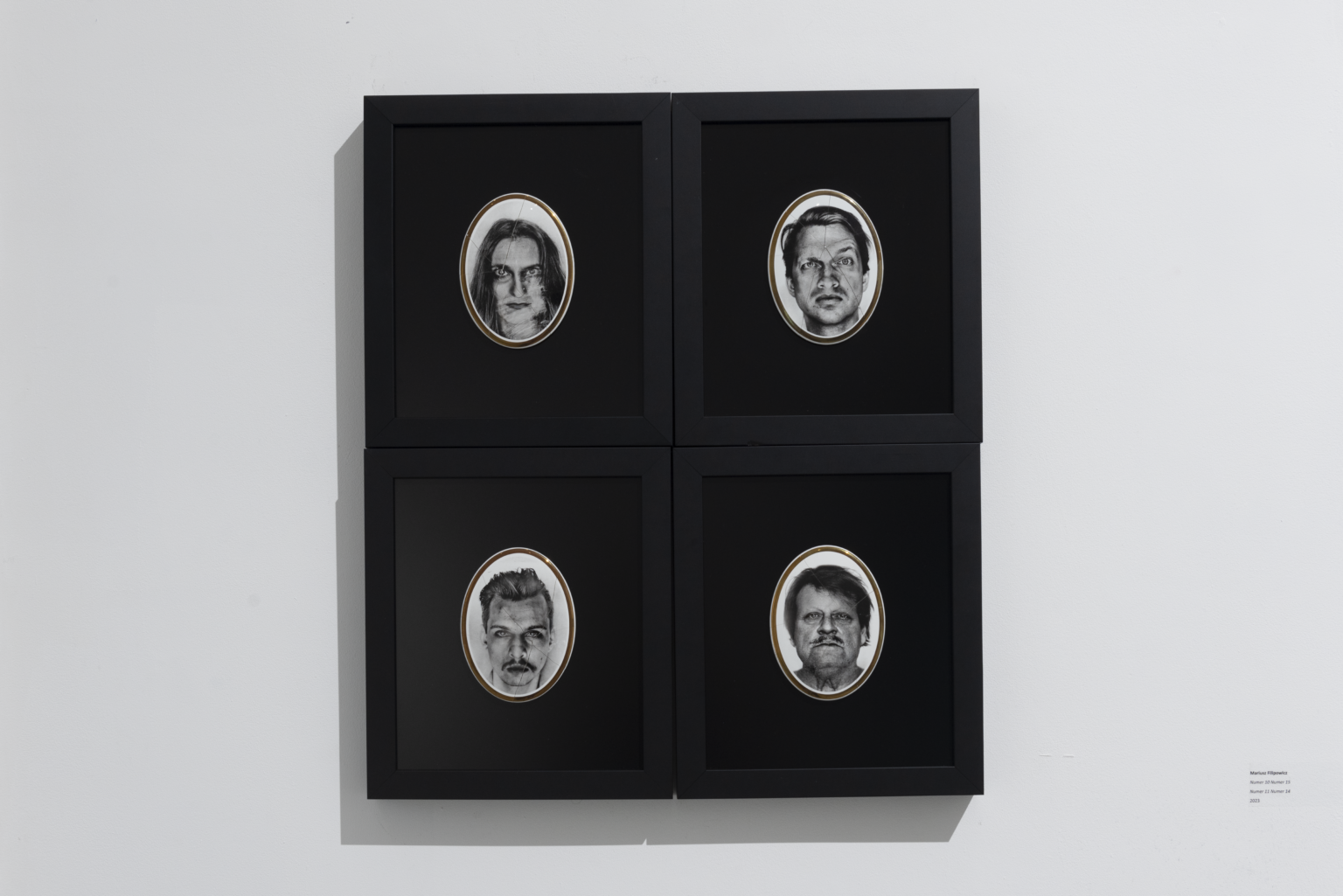 Cztery twarze jako ekspozycja w ciemnych ramkach.