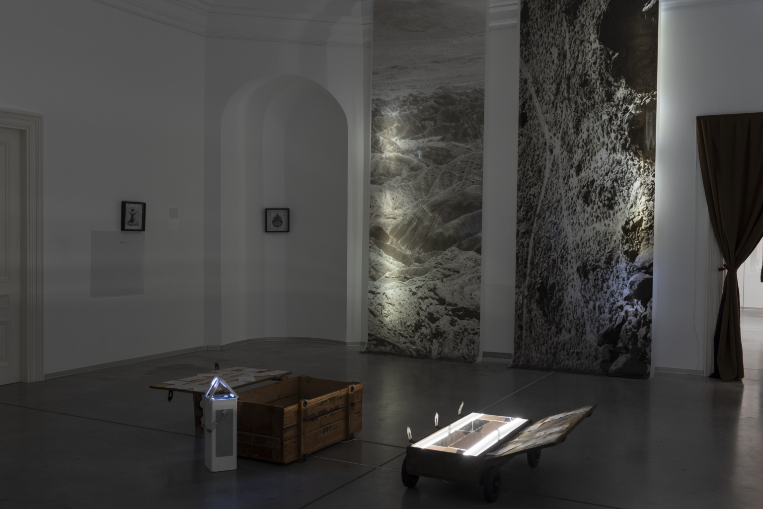 Zdjęcie z wystawy. W tle prace artystów.