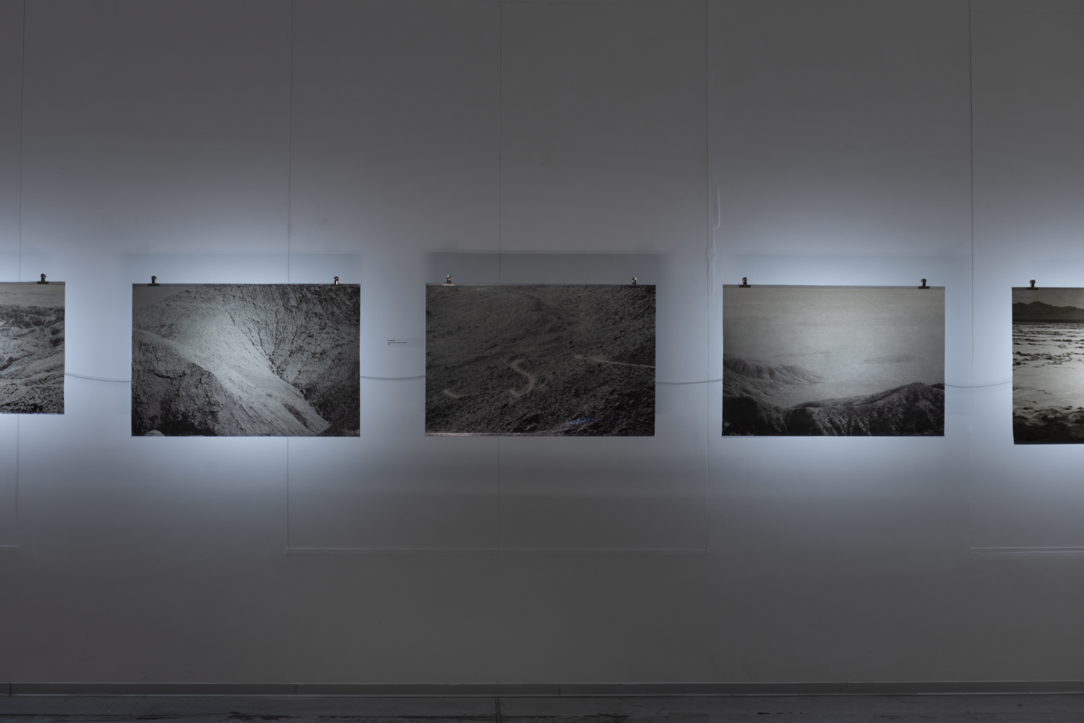 Trzy prace wiszące na białej ścianie.