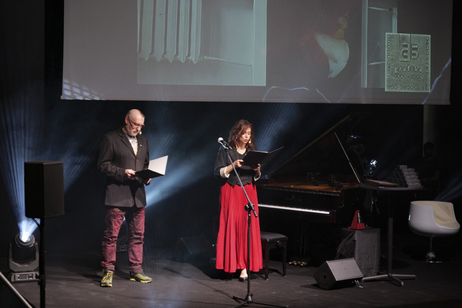 Kobieta i mężczyzna przemawiający na scenie.