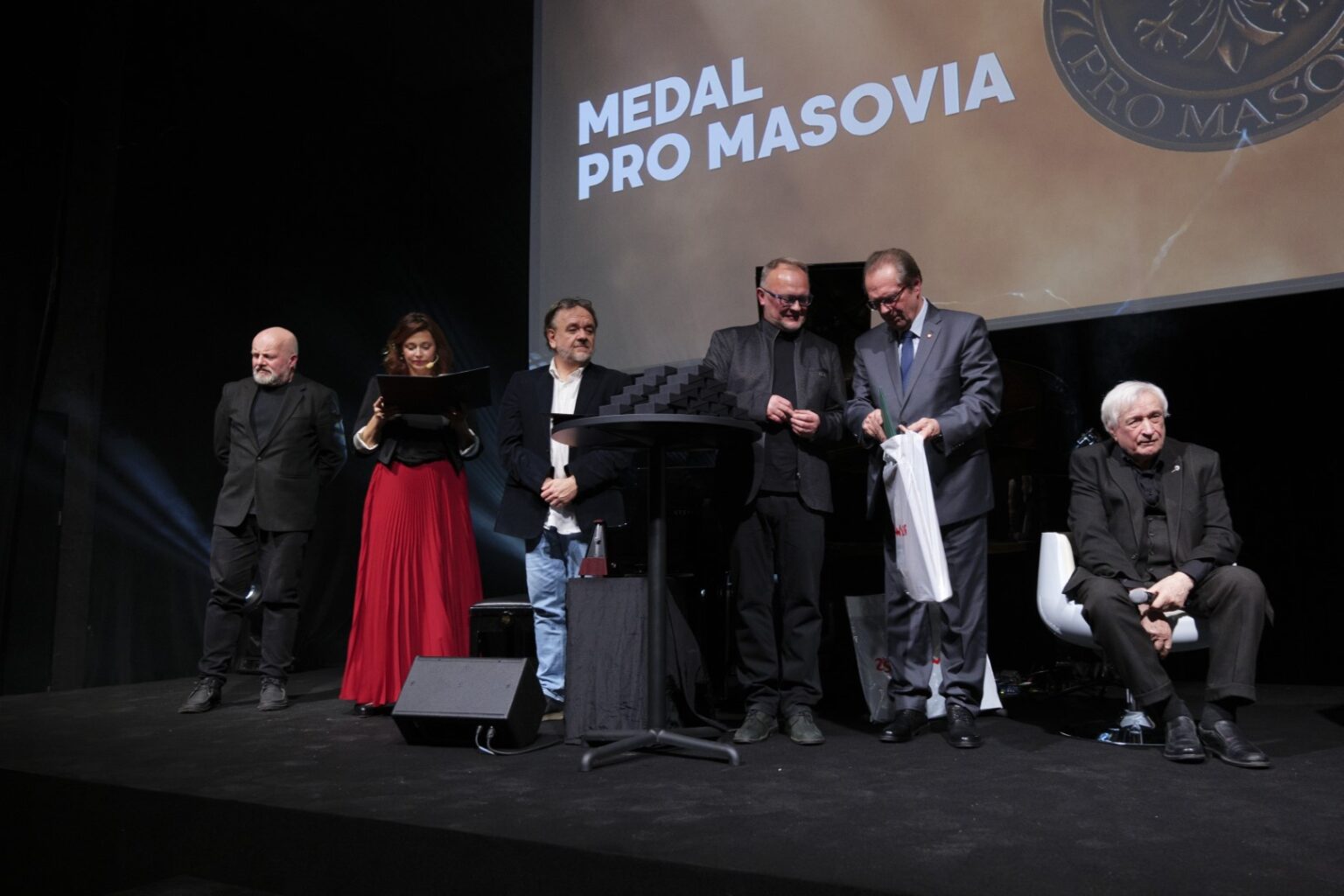 Grupa osób stoi na scenie podczas rozdania nagród.