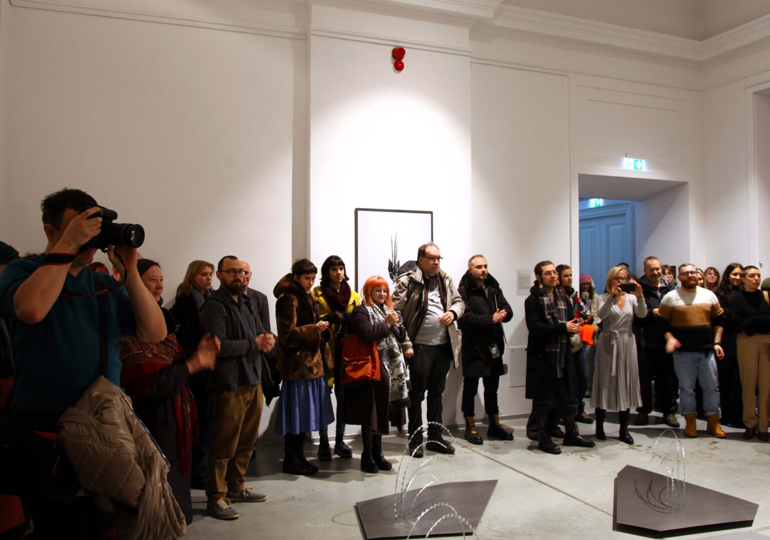 Duża grupa osób w przestrzeni galerii