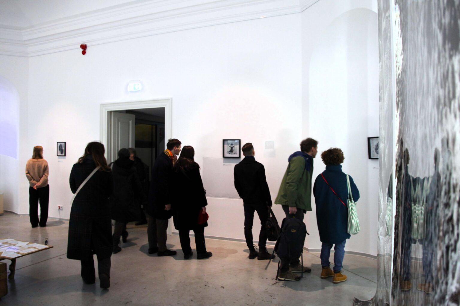 Zwidający oglądają eksponaty na ścianach