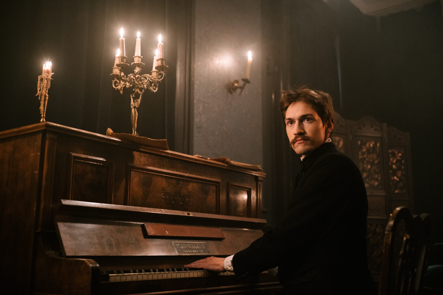 Młody mężczyzna grający na pianinie.