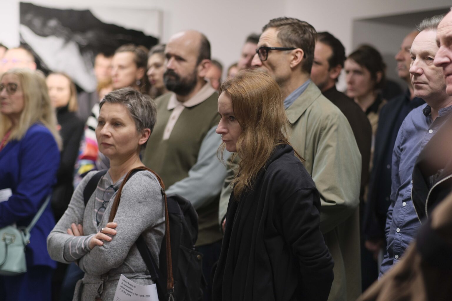 Grupa zasłuchanych osób zwiedzających