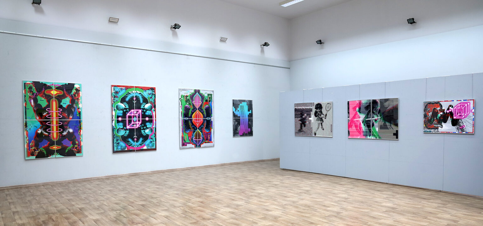 Zdjęcie przestrzeni wystawy. Na białych ścianach wiszące prace.