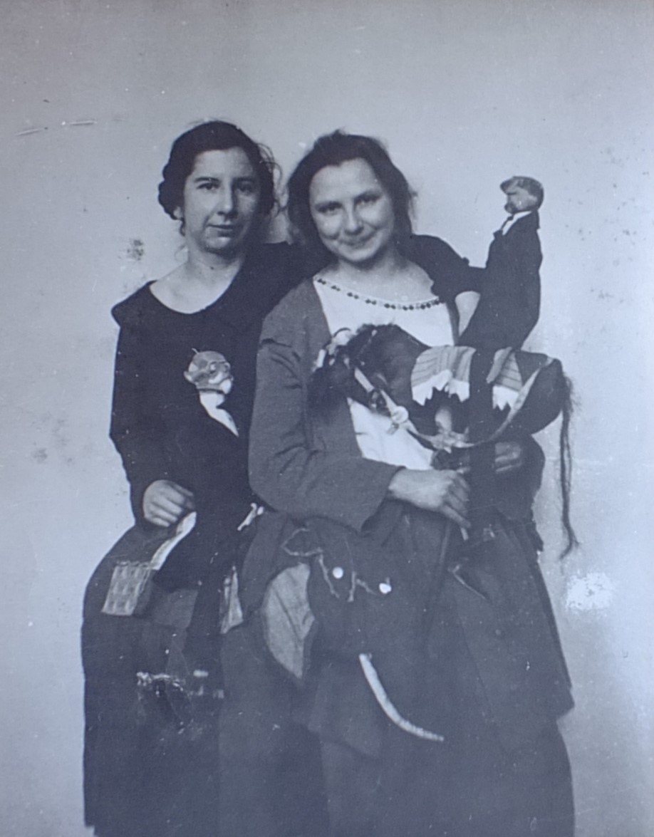 Czarno-biały portret dwóch kobiet trzymających w dłoniach kukiełki