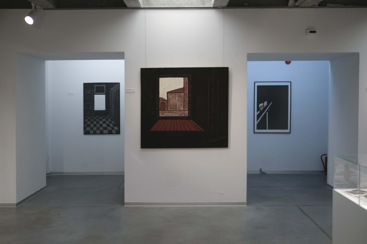 Widok trzech obrazów w przestrzeni galerii