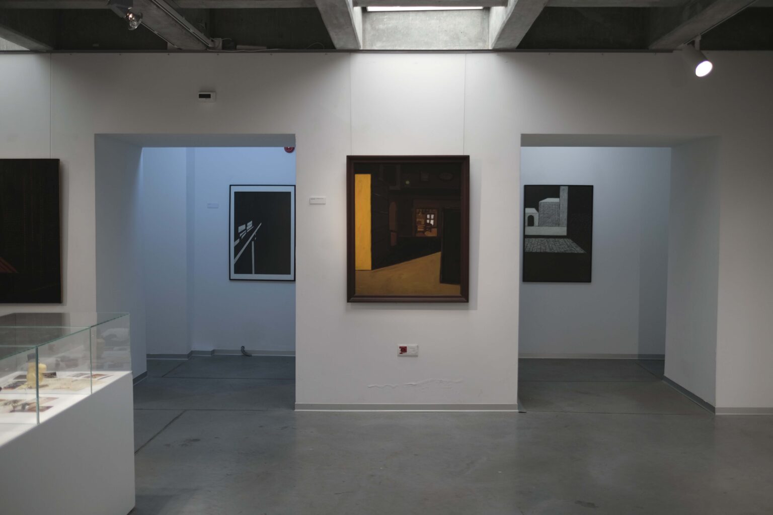 Widok trzech obrazów w przestrzeni galerii