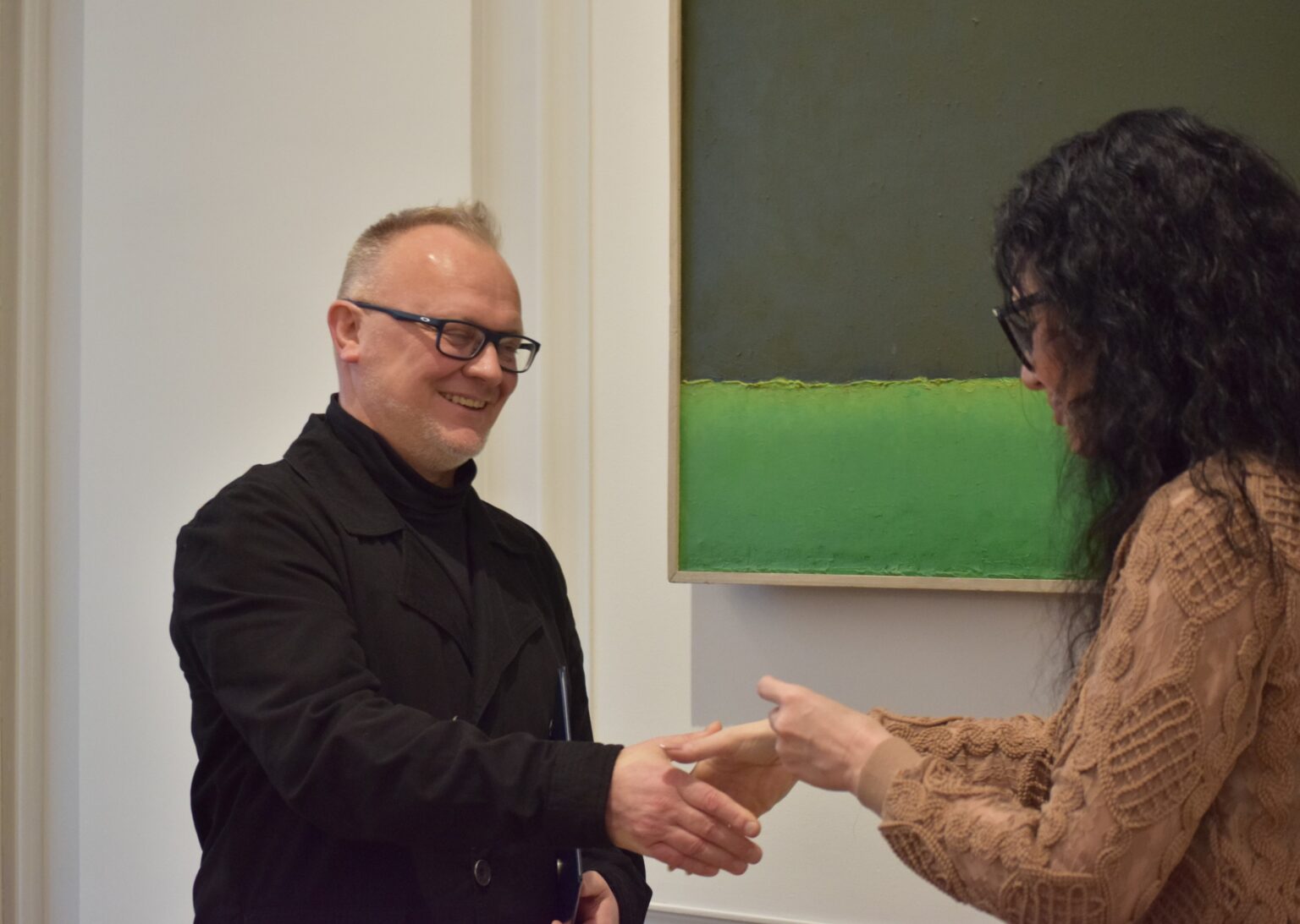 mężczyzna i kobieta (tyłem). Uścisk dłoni.