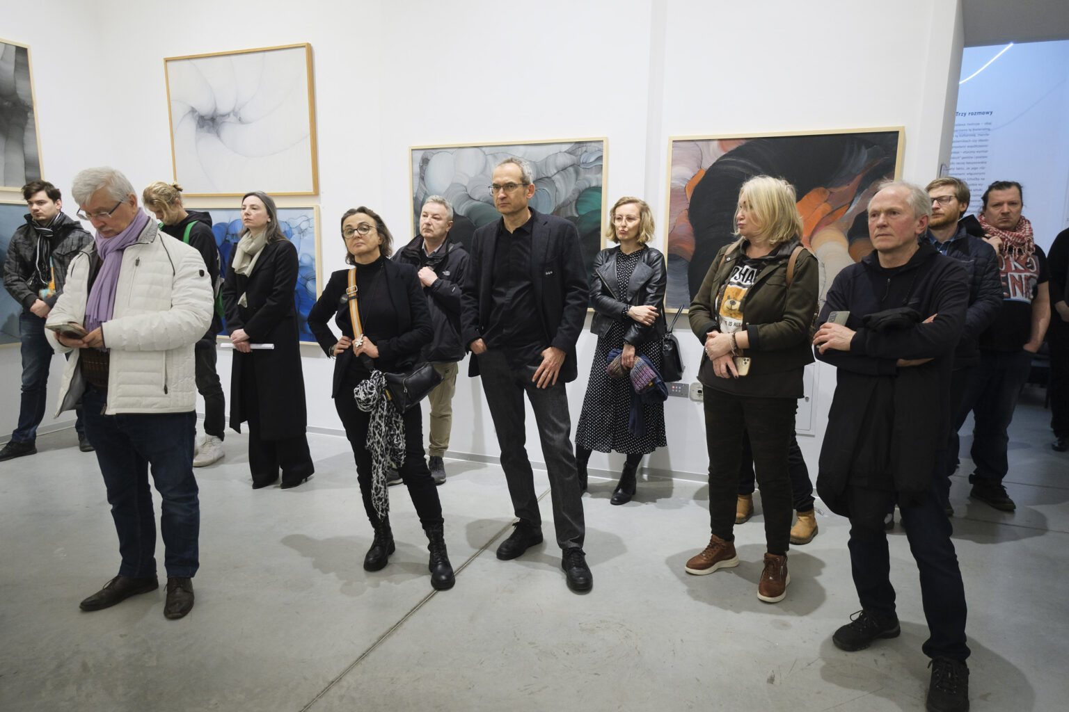 Duża grupa osób w przestrzeni galerii