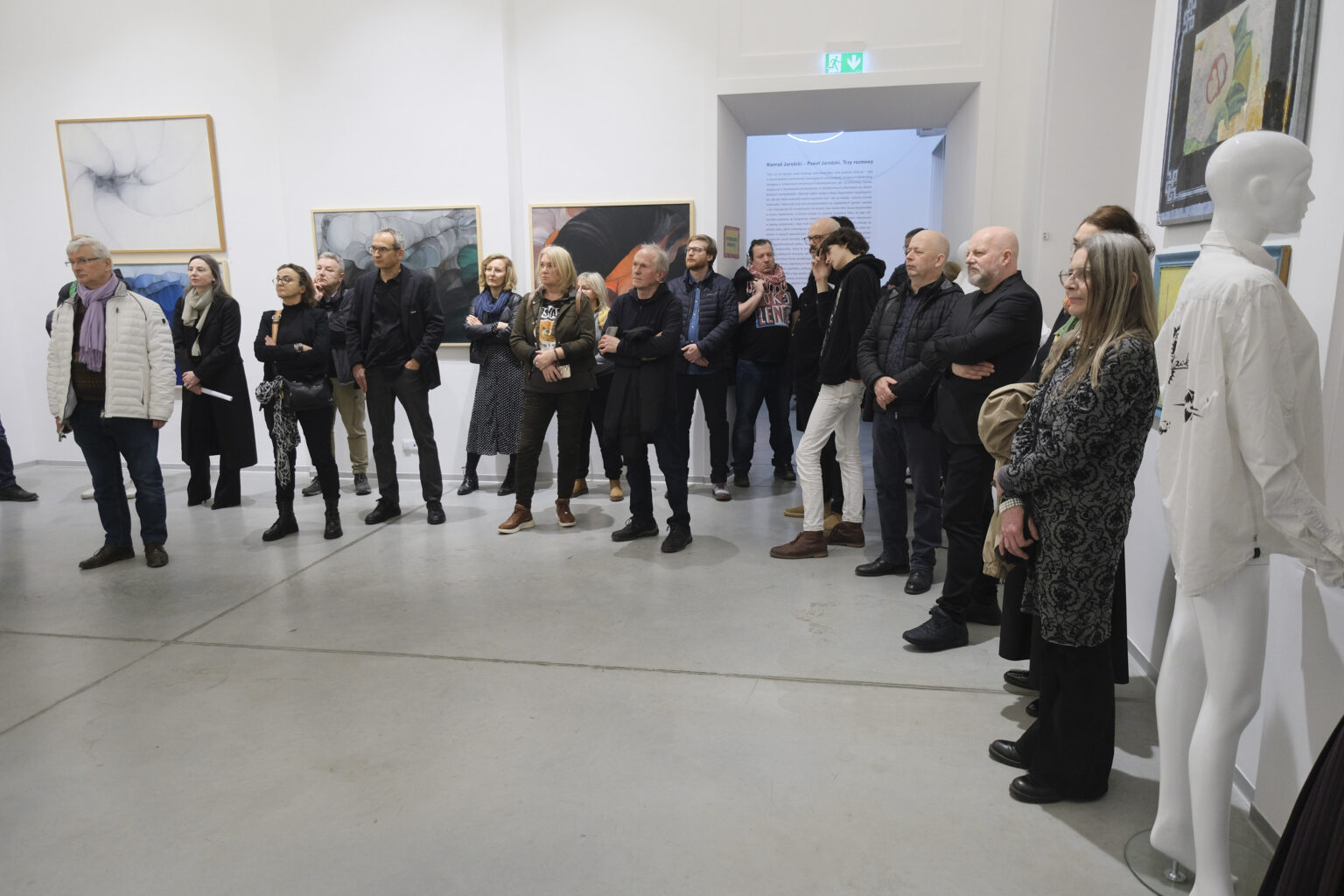 Duża grupa osób w przestrzeni galerii