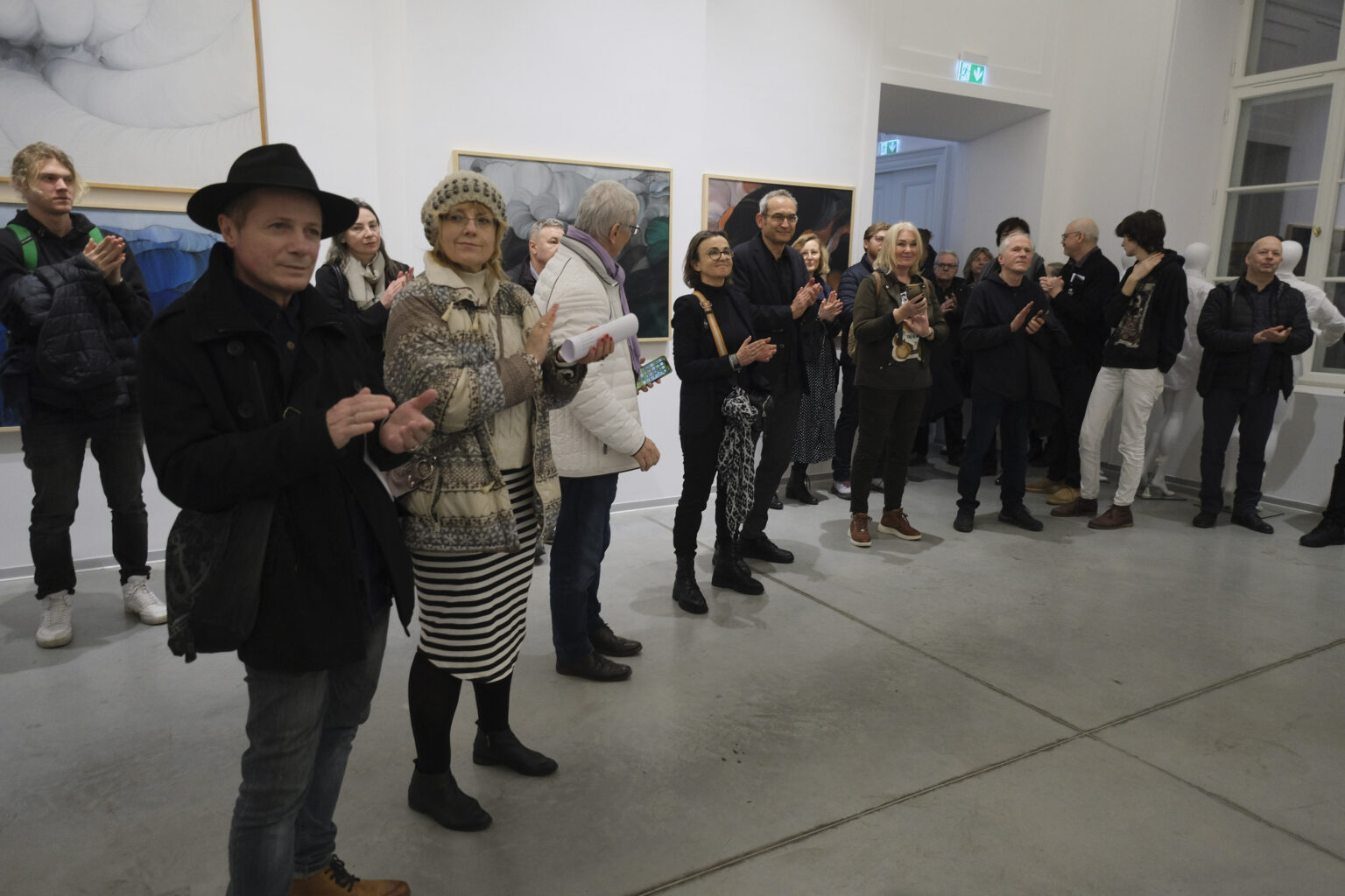 Duża grupa osób w przestrzeni galerii