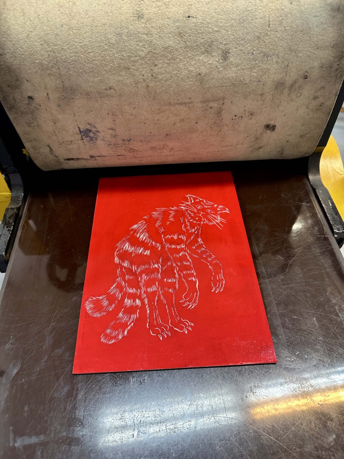 Grupa dzieci przy dużym stole podczas warsztatów. Na stole przybory do rysowania