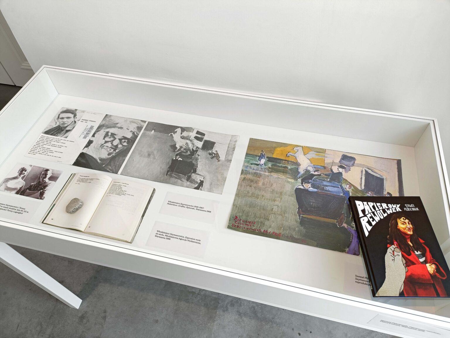 Gablota z eksponatami, na niej książka