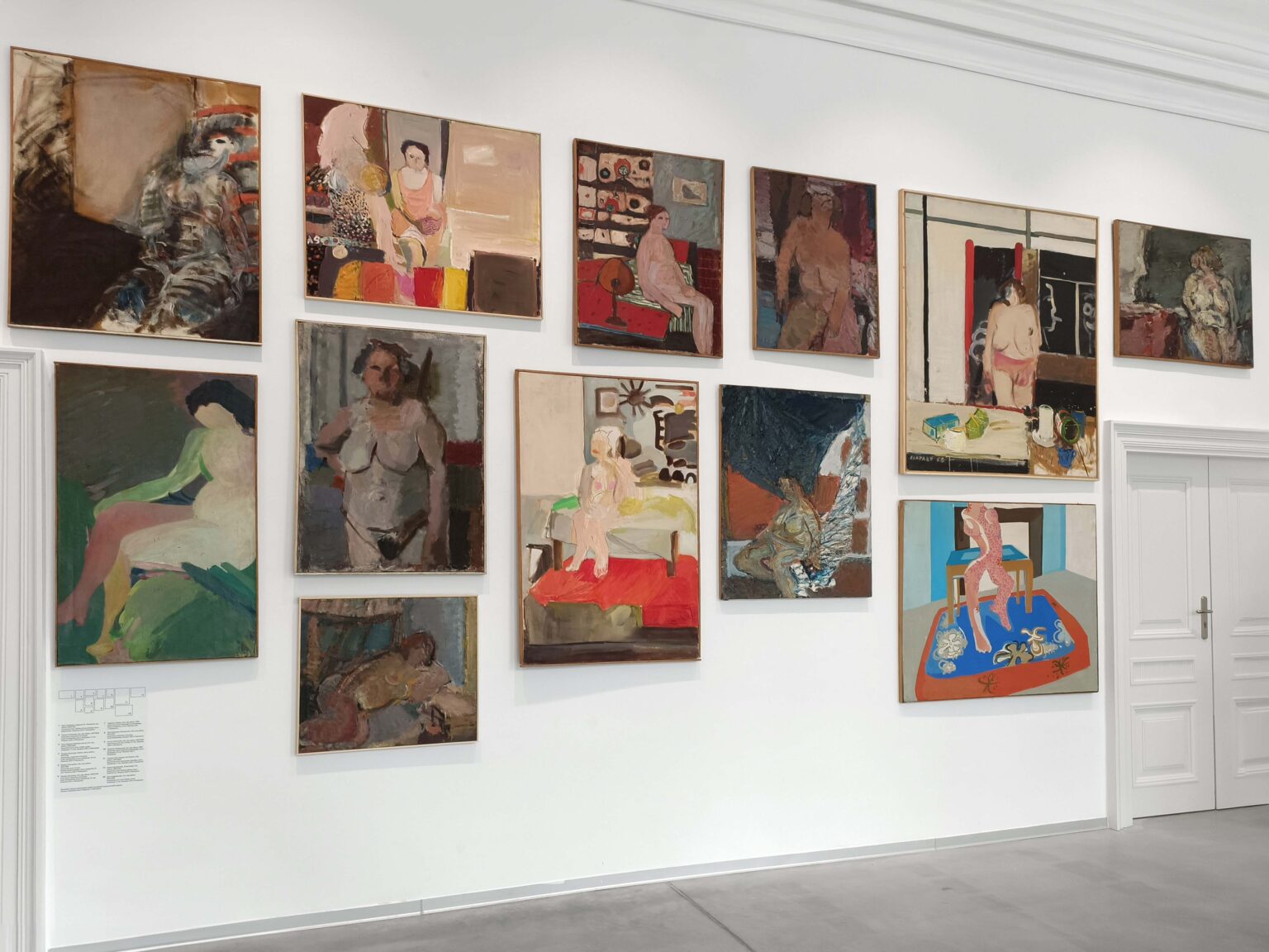 Ściana galerii wypełniona barwnymi obrazami