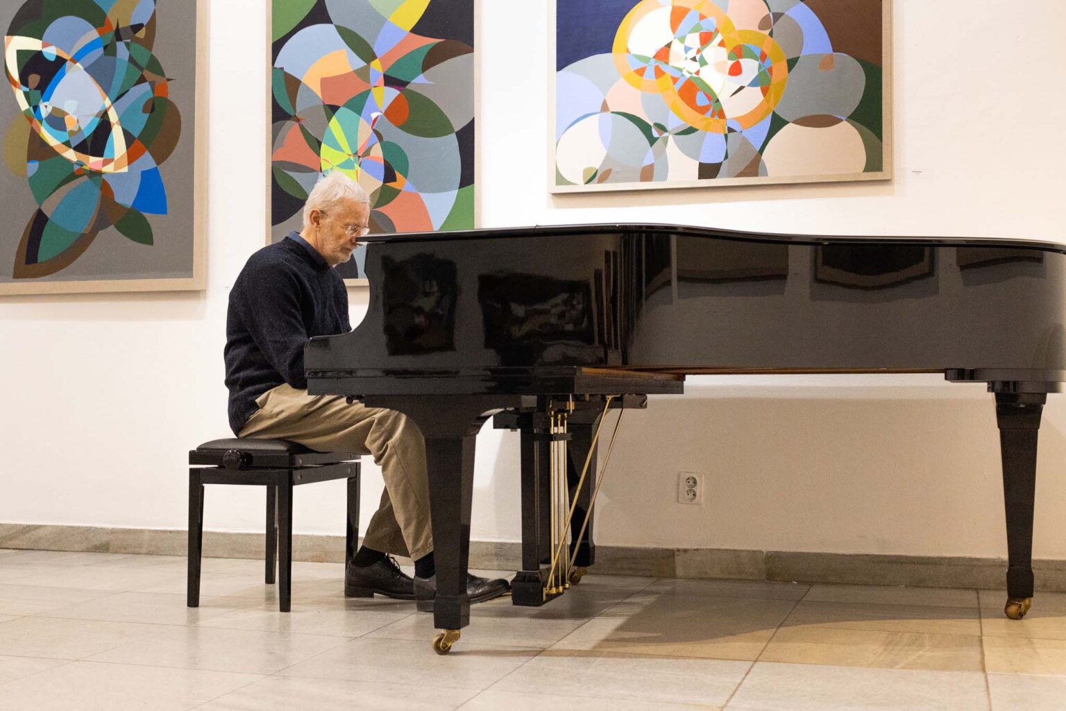 Mężczyzna przy fortepianie. Obrazy w tle