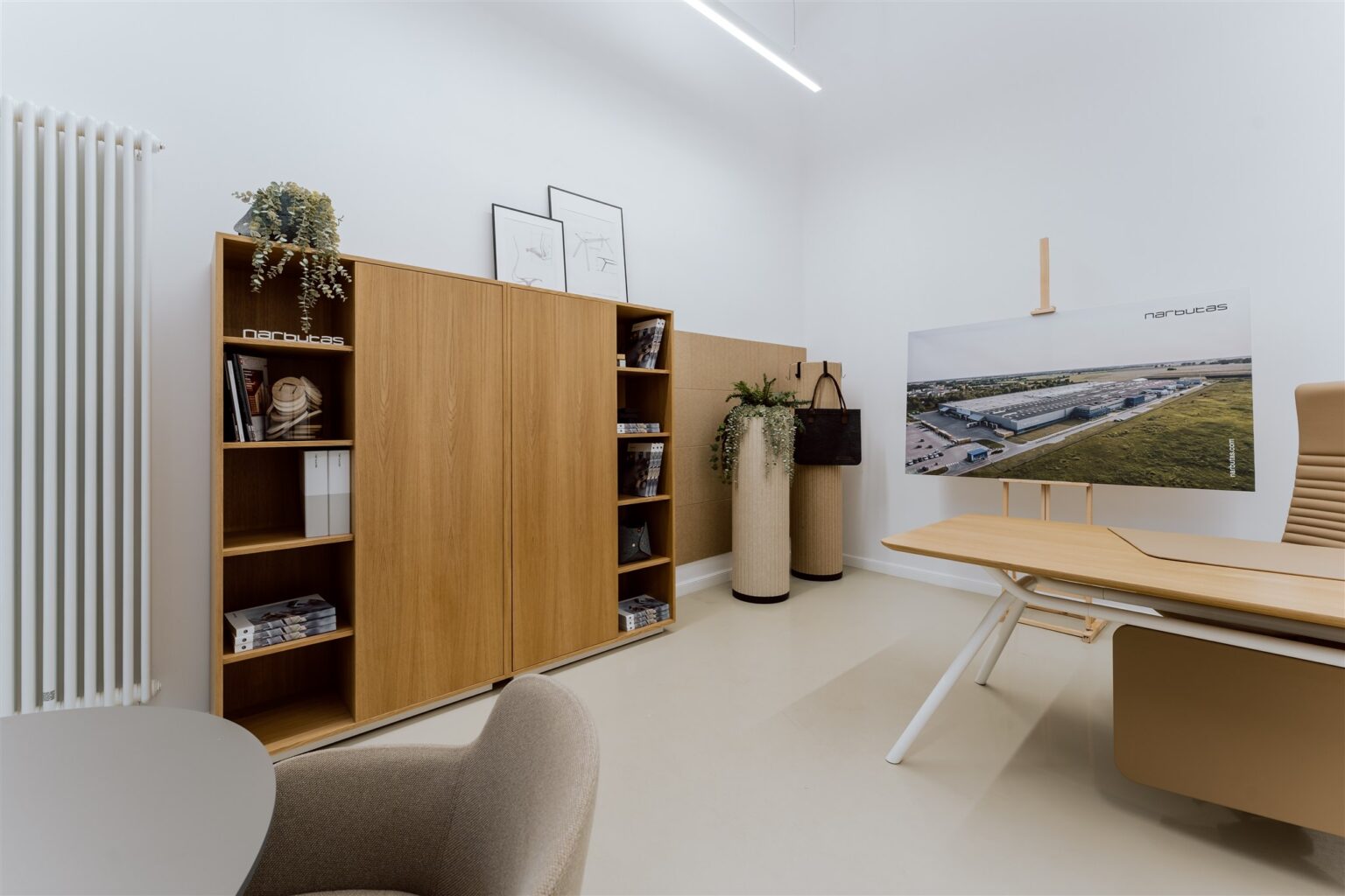 Wnętrze jesnego pomieszczenia: fragment biurka i regał