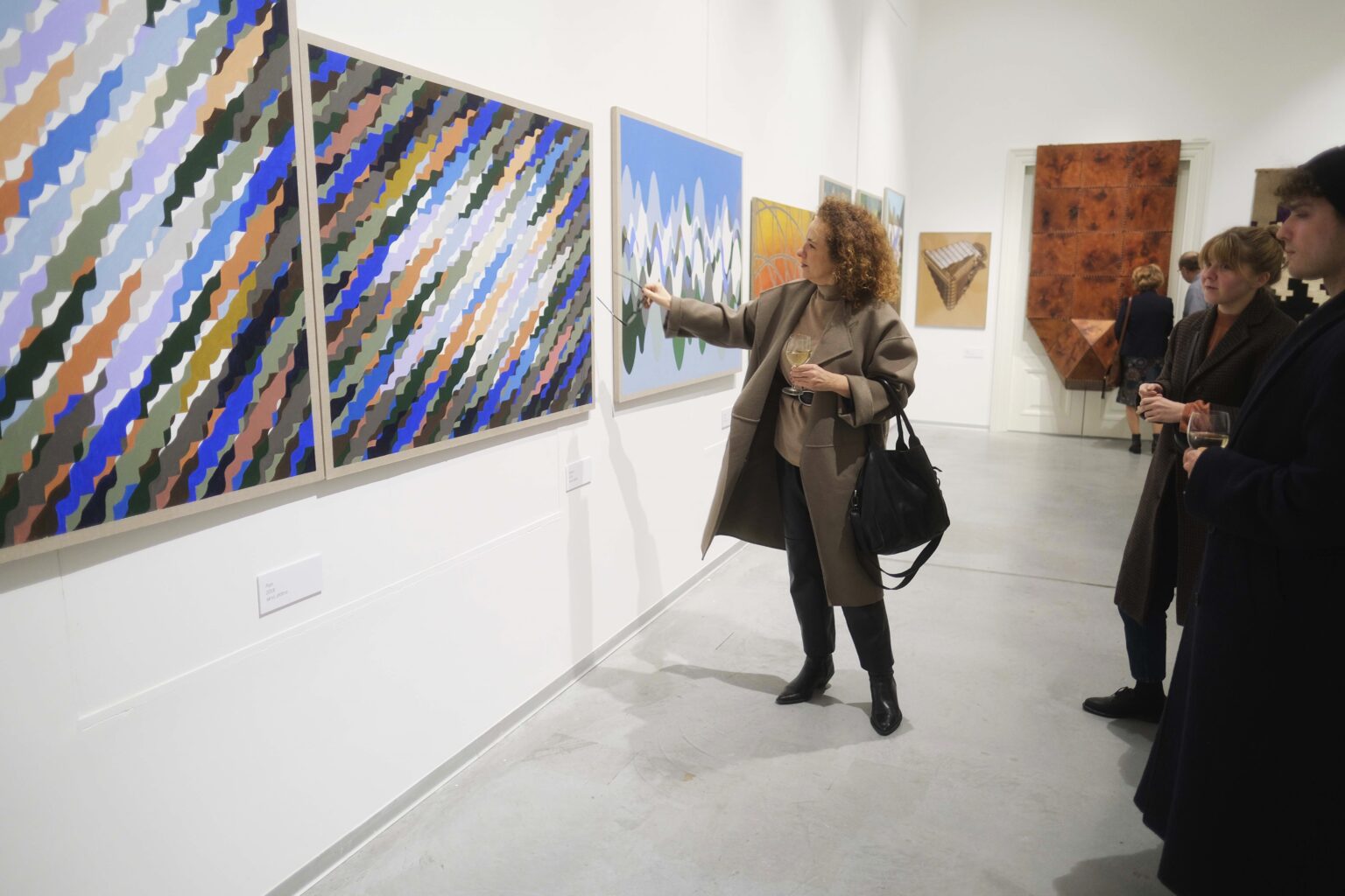 Kobieta wstazująca na jeden z obrazów na ścianie