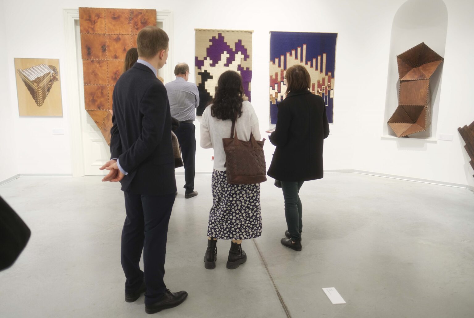 Zwiedzający wystawą, obrazy na ścianach