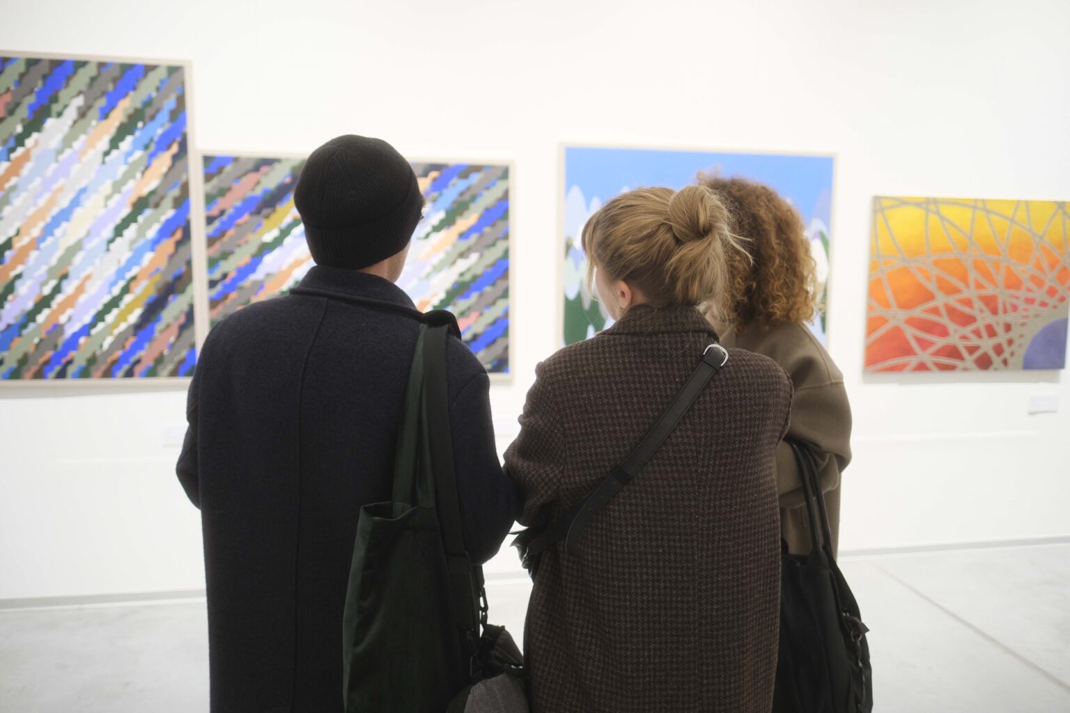 Zwiedzający wystawą, obrazy na ścianach