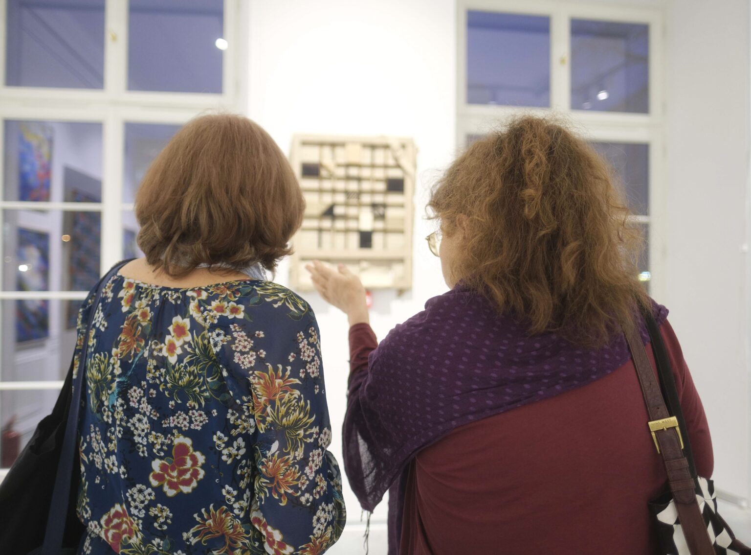 Zwiedzający wystawą, obrazy na ścianach