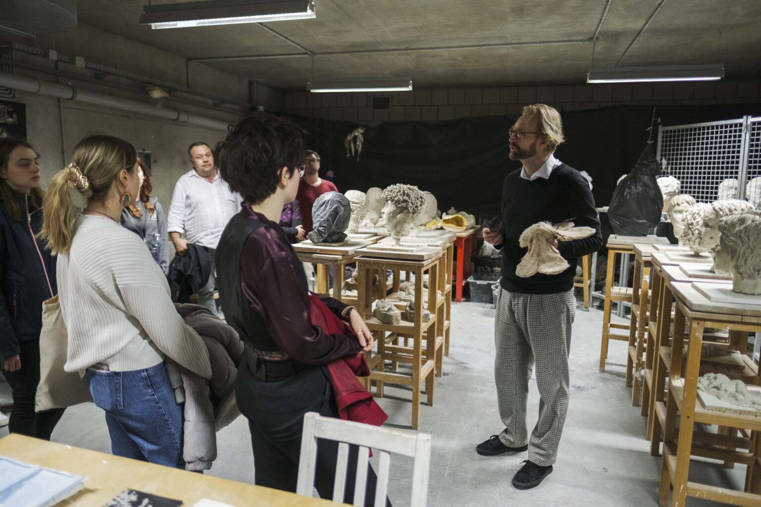 osoby w pracowni, mężczyzna mówi do grupy