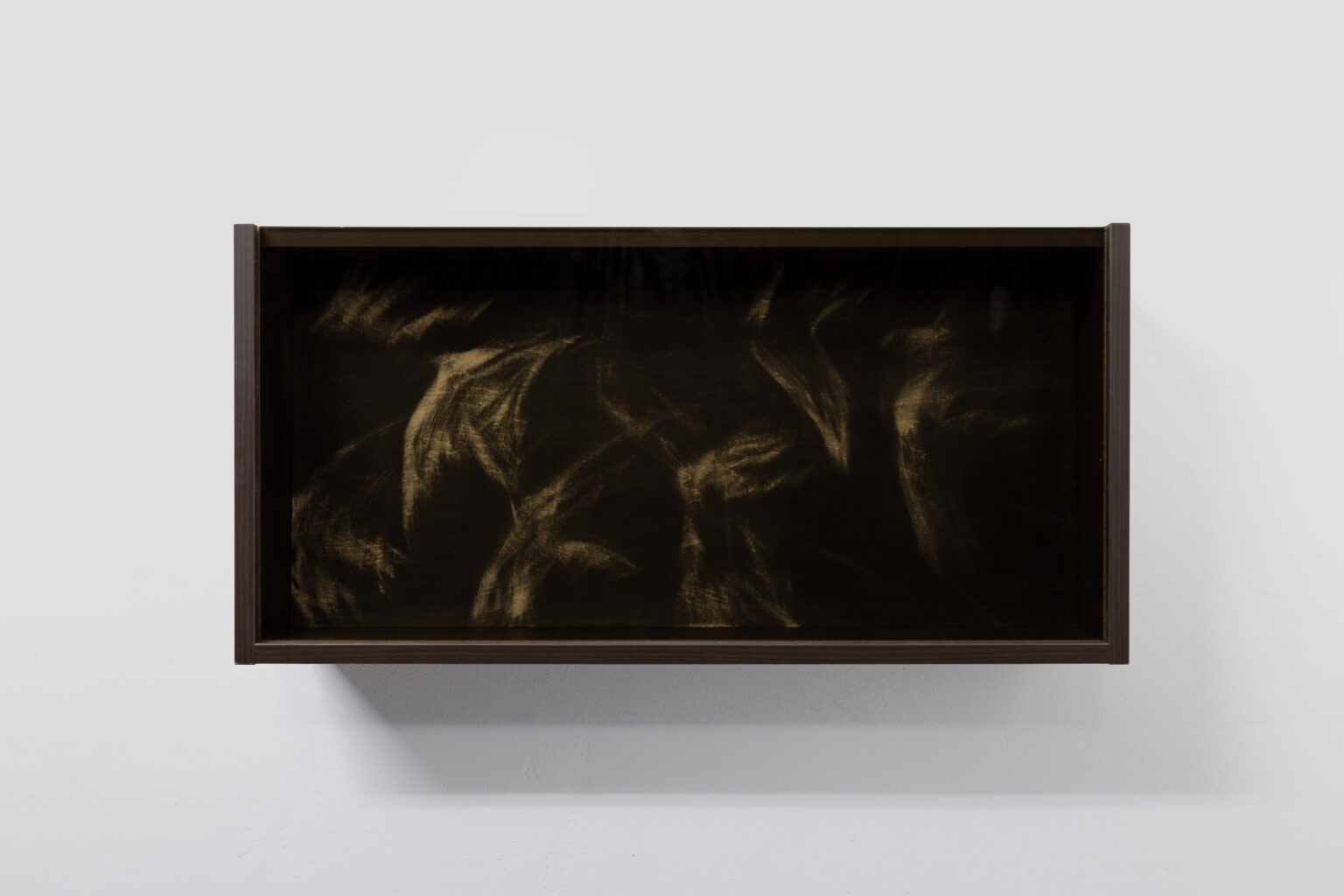 Prostokątny, poziomy obraz w ciemnych barwach w brązowej ramie.