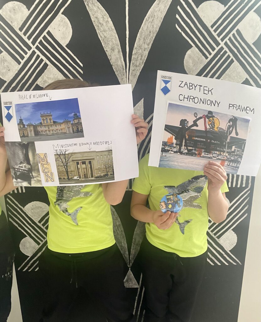 Dzieci prezentują swoje plakaty trzymając je w górze na wysokości twarzy